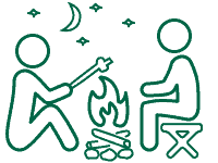 Volunteer Vacation Icon of two people sitting around a campfire under a starry sky