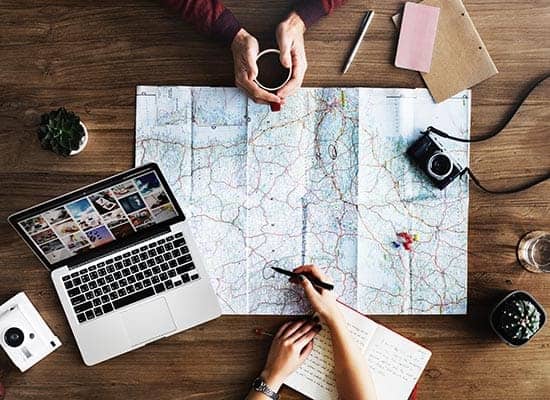 a couple plans a trip with a table full of hiking resources