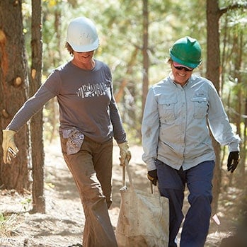 Volunteer Vacation participants haul materials to a trail project site.