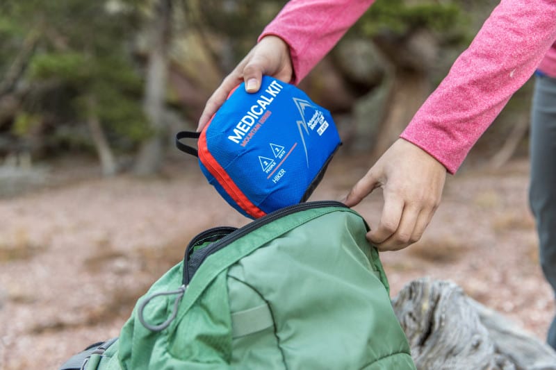 A hiker prepares for a hiking adventure by packing a Hiker Adventure Medical Kit.