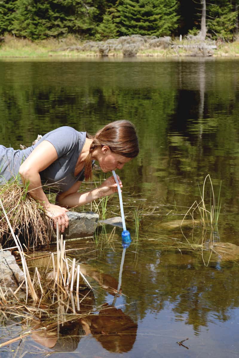 hiker drinks water with a RapidPure water purifier