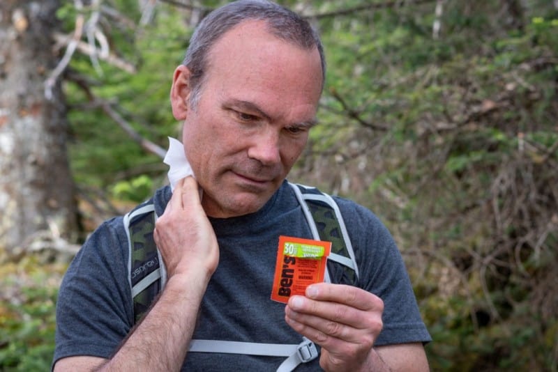Hiker applies bug repellent