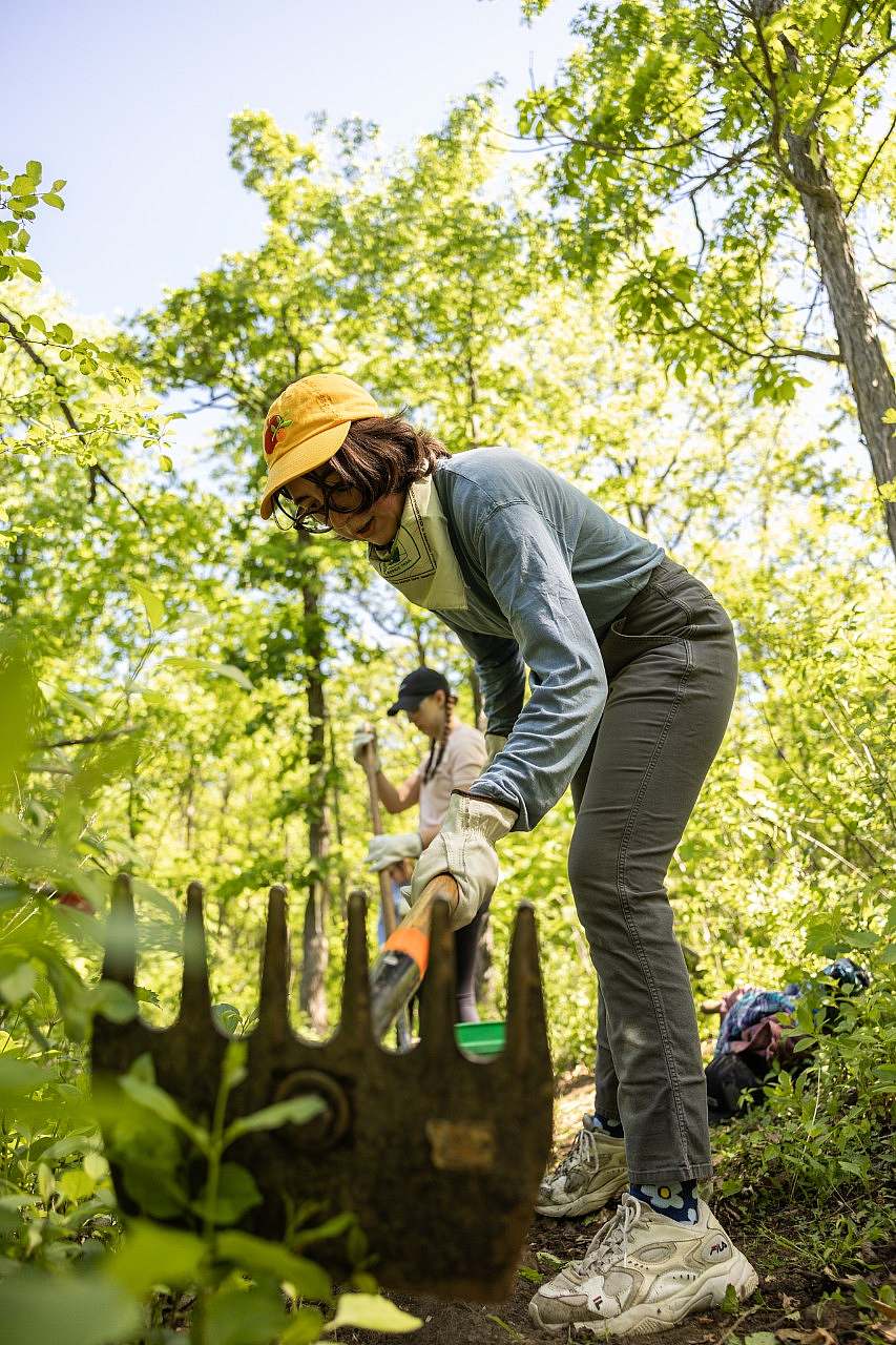 Member of the Duluth Crew scrapes the surface of the trail with a trail tool