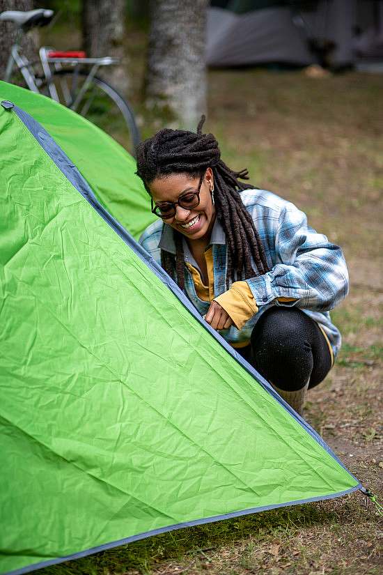 A trip participant zips up their tent