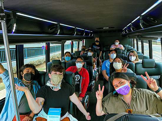 Event participants wear masks in the bus on the way to the trailhead